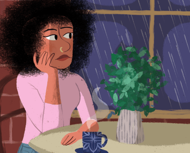 a woman sitting at a table with a cup of coffee. Diane Mulolo Faida