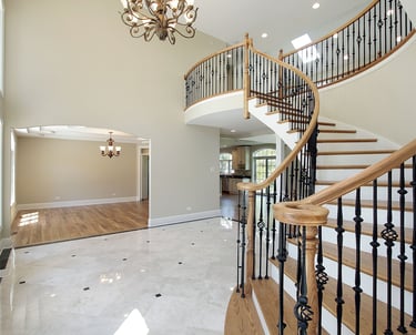 Elegant staircase features rich hardwood treads and handrails with black iron balusters. Vinyl plank