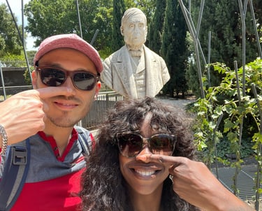 a man and woman posing for a picture in front of a noseless statue