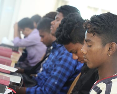 a group of people sitting at a table with books