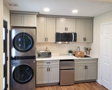 Laundry and kitchenette area with light blue cabinets and stainless steel appliances.