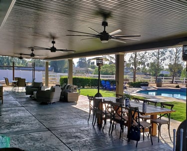 Brown patio cover in large backyard with pool.