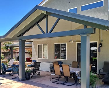 Patio cover with gabled roof line, fiberglass columns. and ceiling fan. Color is Graphite and White,