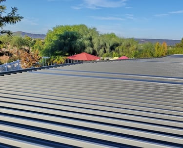 Top of dark grey patio cover overlooking trees and the Santa Rosa Plateau.