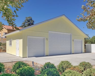 Large yellow RV garage with 3 white sectional doors.