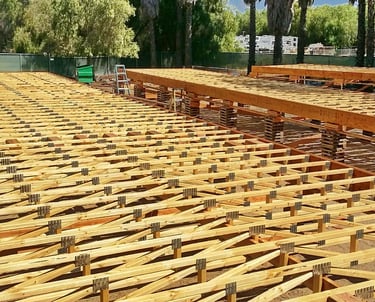 Large modular floor assembly being constructed above ground.