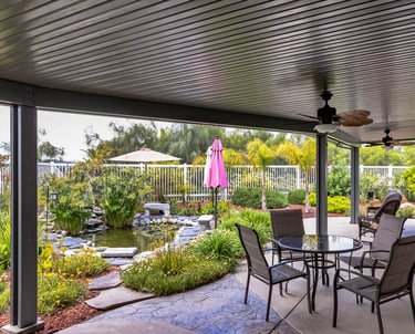 Amazing backyard with tropical plants and fish pond veiwed from under a covered patio.