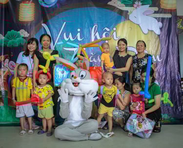a group of people posing for a photo with a bunny on the ground