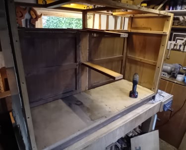Rear view of the cupboard sitting on a workbench. It has no back panel or internal supports.