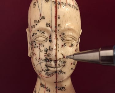 eine asiatische Kopfstatue mit aufgemalten Akupunkturpunkten