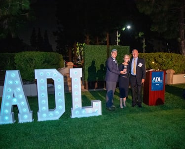 a man and woman standing in front large marque letters