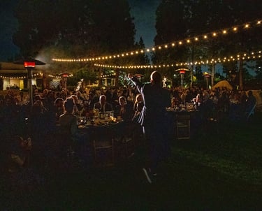 a man standing in front of a crowd of people fundraising event planner