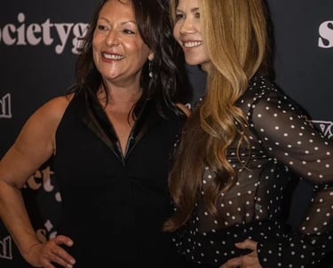 two women standing next to each other on a red carpet event planner