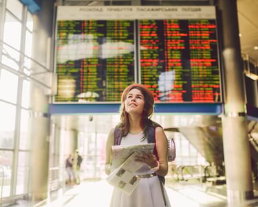 a woman in a white dress is holding a map and looking up at the sky
