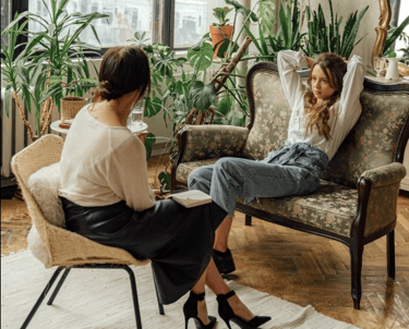 a woman sitting on a chair in a room with a therapist