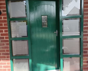 a freshly painted green door with a number on it