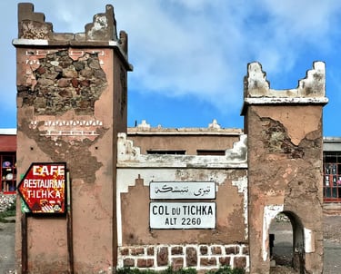 Crumbling buildings at Tizi n'Tichka with sign reading 'Col du Tichka Alt 2260m'