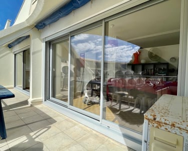 Baies vitrées avec systèmes coulissants pour l'accès à la terrasse d'un appartement.