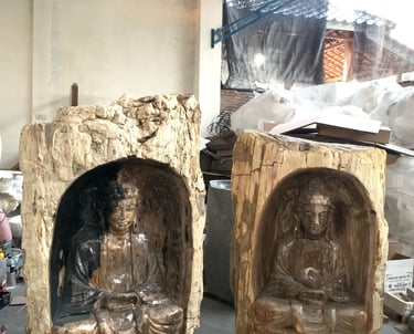 Two Buddha sculptures carved within solid petrified wood blocks — Part of Arcanum.