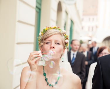 a bride and groom blowing bubbles in the air