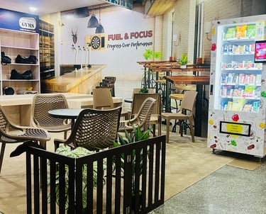 FitX1 Manikonda relaxing lounge and cafe with snack vending machines and member shoe storage area.