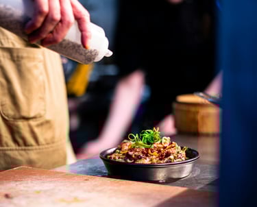 chef is pouring sauce over a delicious oven dish ready to be served