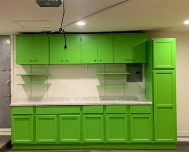a kitchen with green cabinets and white counter tops