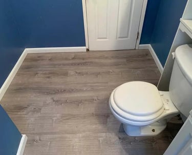 a toilet in a bathroom with a toilet and a toilet paper roll