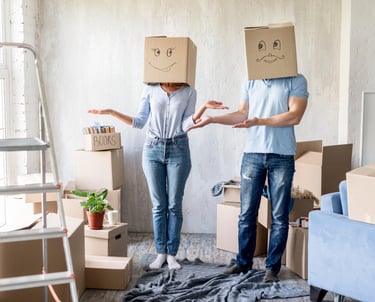 Woman and man moving in, wearing boxes on their head with funny faces drawn on them.