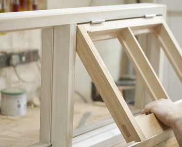 a man is holding a window pane of a window