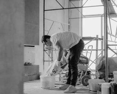 a man in a white shirt is painting a wall
