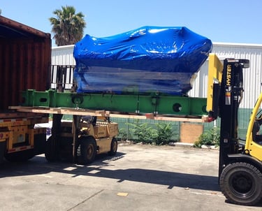 a large product with blue covered being loaded into a truck
