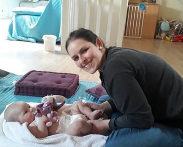 femme souriante massant son bébé