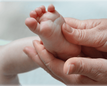 mains massant un pied de bébé