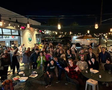 a group of people standing around tables with drinks