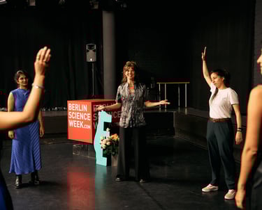 Women on a theatre stage warming up together before a storytelling event