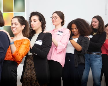 Women standing in a line with hands on each other’s backs, showing mutual support and connection
