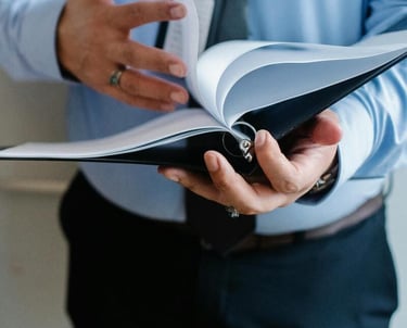Un hombre de negocios hojea las páginas de una carpeta para gestionar documentos de oficina.