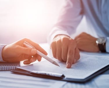 A business professional points to a legal document during a contract signing or consultation.