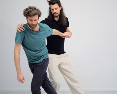 practitioner holding client at shoulder and arm as they move through the room