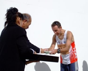 Coach Scott Brown receiving a prize for an age graded win in the Kawachinagano half marathon.