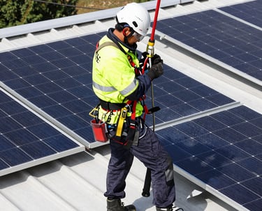 Technician inspecting solar panels on a sunny rooftop.