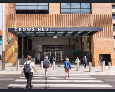 Commuters walking across a Crows Nest Metro entrance