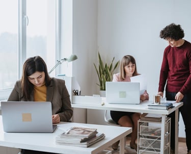 Personas trabajando en sus escritorios con computadoras 