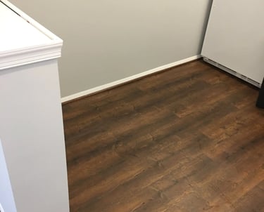 Dark wood-look vinyl plank flooring installed in kitchen.