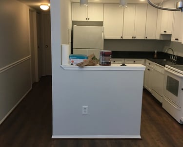 Dark wood-look vinyl plank flooring installed through the hallway, kitchen, and dining area.
