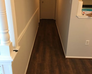 Dark wood-look vinyl plank flooring installed through the hallway.