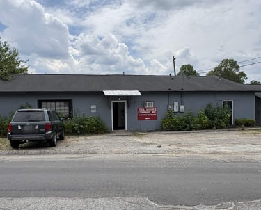 Exterior view of Tool Service Company Inc. storefront with customer entrance sign and parked SUV.