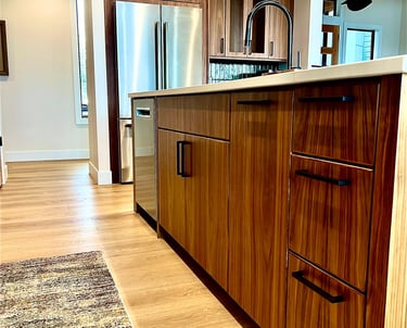 Modern kitchen with walnut wood cabinets, stainless steel appliances, and a black faucet.