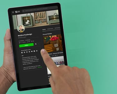 Person browsing a 3D modeling profile on a digital tablet with a green background.